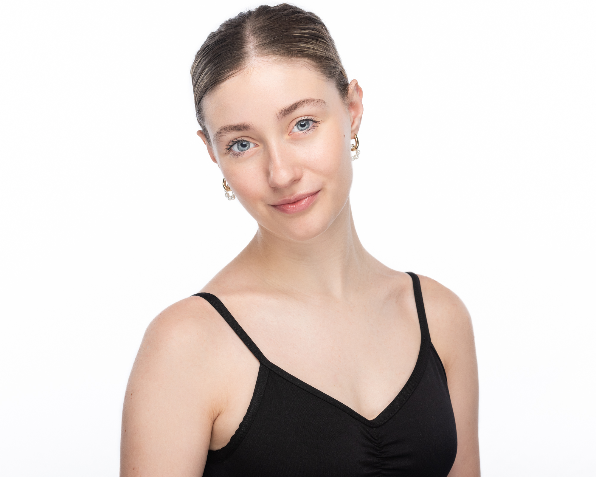 Headshot on a white background of a young female ballet dancer